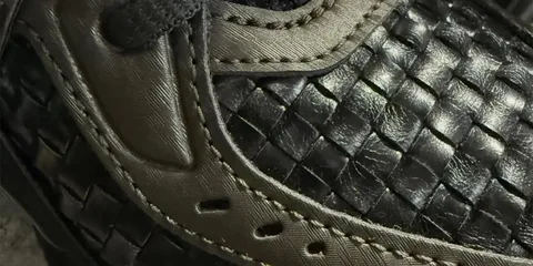 Gros plan sur une chaussure en cuir tressé noir avec coutures.