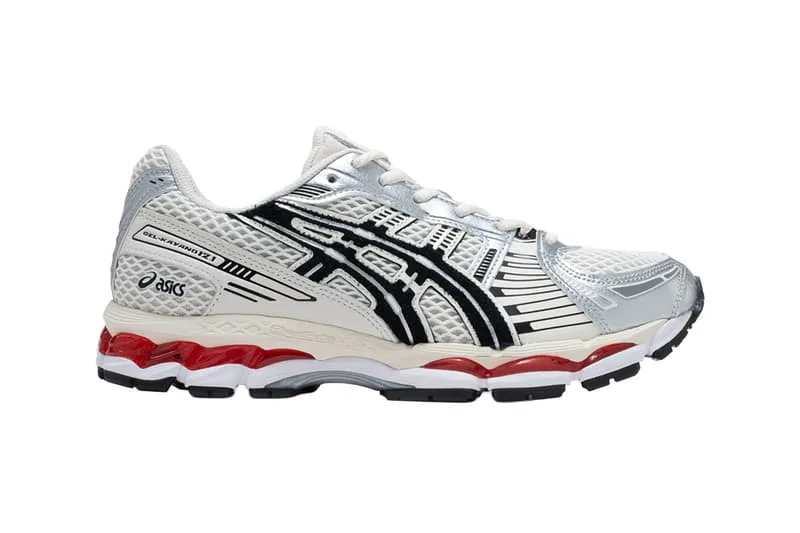 Chaussure de sport Asics blanche et argent avec détails noirs et rouges.
