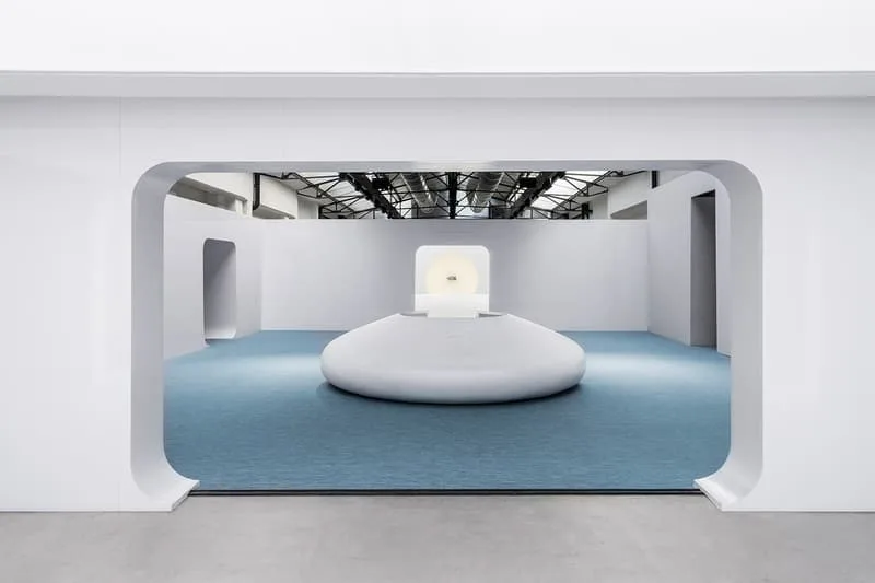 Espace minimaliste avec des murs blancs et une installation centrale.