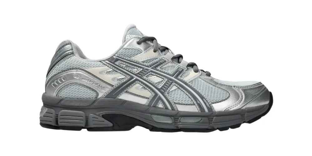 Chaussure de sport grise et argentée avec logo latéral.