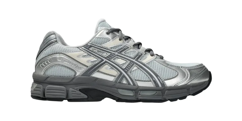 Chaussure de sport grise et argentée avec logo latéral.