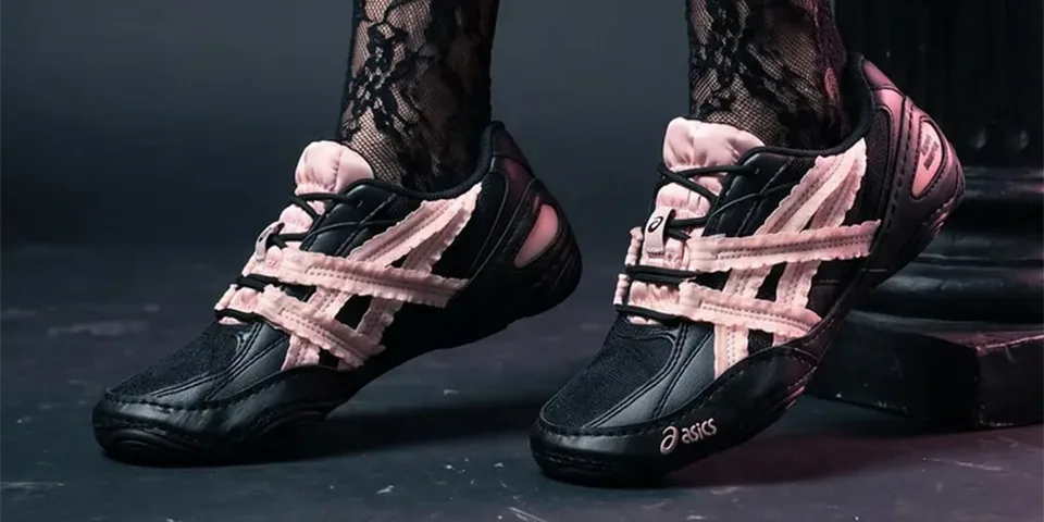 Chaussures Asics noires et roses portées avec des bas en dentelle.