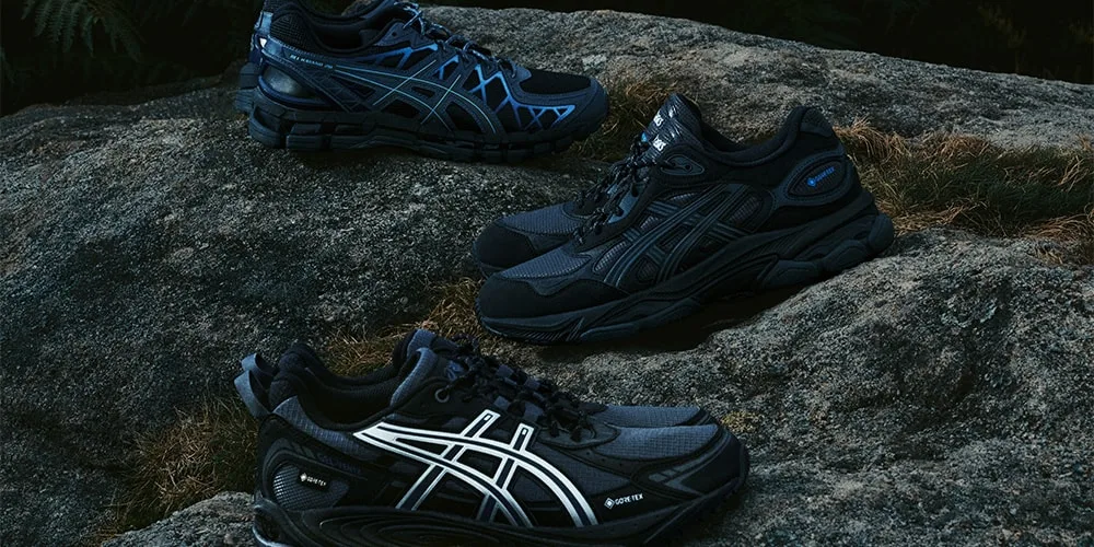 Trois paires de baskets noires et bleues sur un rocher.
