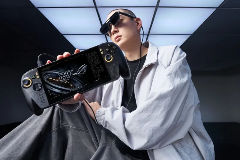 Personne avec une console de jeu portable, habits modernes et lunettes de soleil.