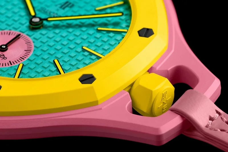 Montre colorée avec cadran turquoise et bracelet rose, pièces jaunes et roses.