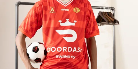 Joueur en maillot rouge DoorDash avec ballon de football