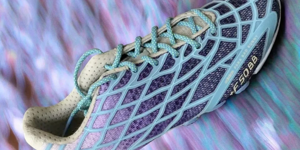 Chaussure de sport rayée bleue et violette sur fond coloré.
