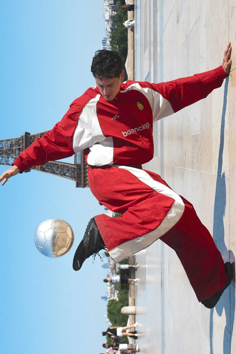 Personne jouant au football devant la tour Eiffel.