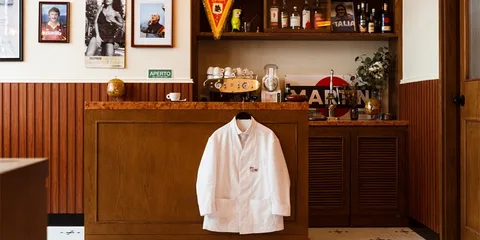 Intérieur de restaurant avec bar et veste blanche accrochée.