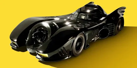 Voiture noire futuriste avec ailettes sur fond jaune