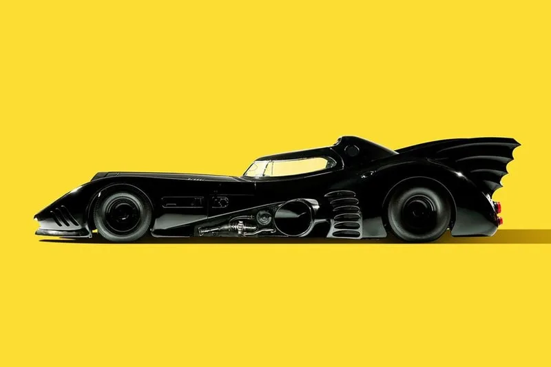 Voiture noire emblématique sur fond jaune vif, design futuriste.