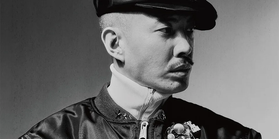 Portrait en noir et blanc d’un homme portant une casquette et une veste sombre.