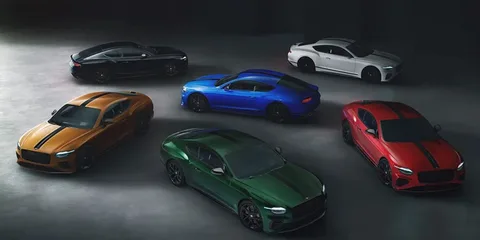 Six voitures sportives de différentes couleurs dans un studio sombre.