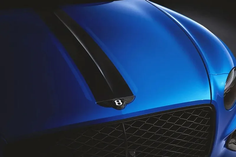 Voiture bleue avec capot noir et logo B visible