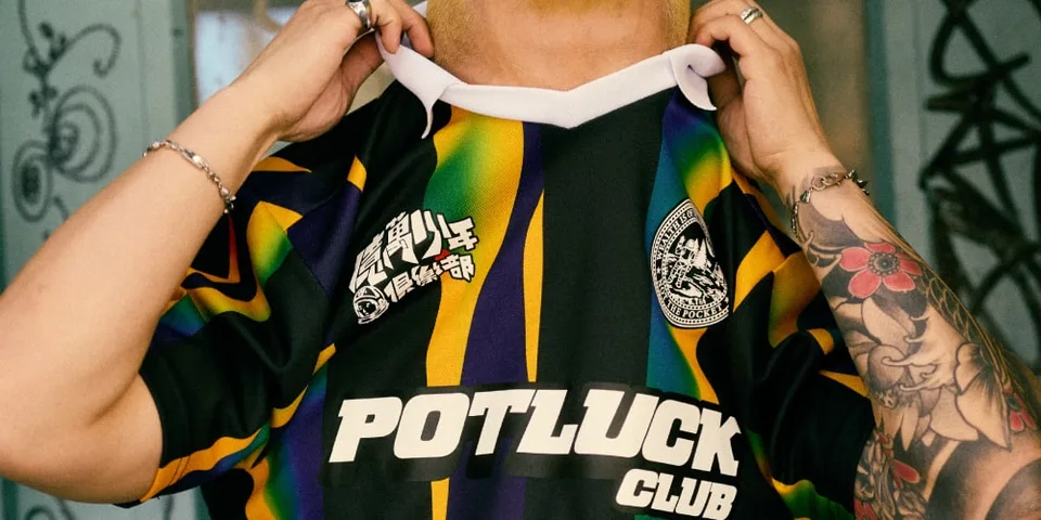 Personne portant un maillot coloré avec 'POTLUCK CLUB' et des motifs graphiques.