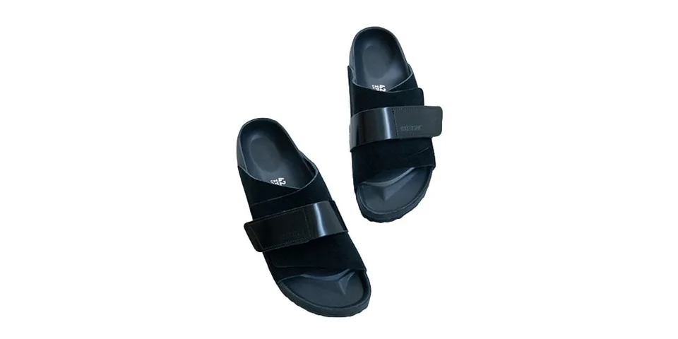 Paire de sandales noires avec sangle avant, fond blanc.