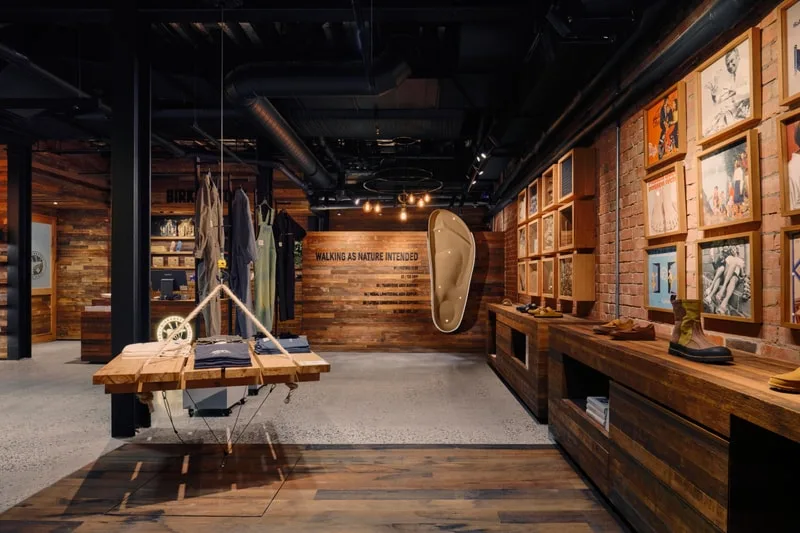 Intérieur d'une boutique avec un design moderne en bois et des chaussures exposées.