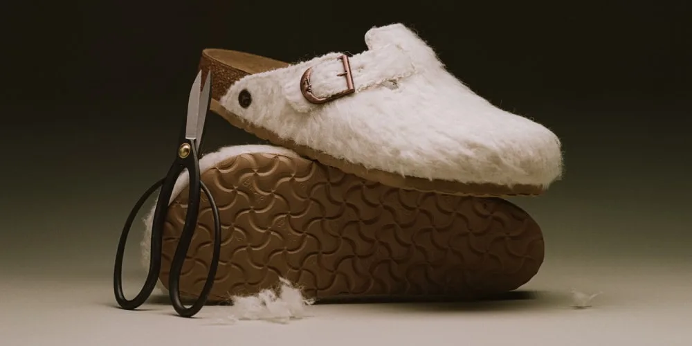 Chaussure en peluche blanche avec semelle brune et ciseaux noirs.