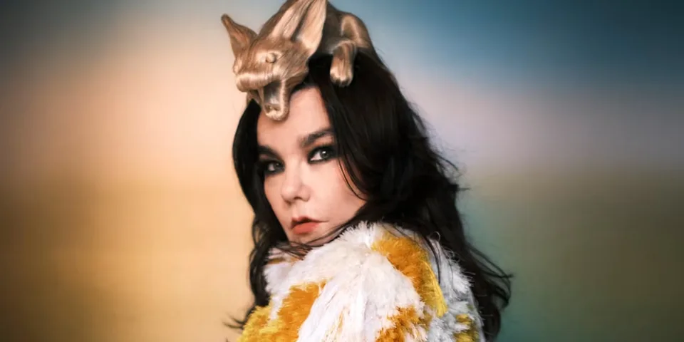 Femme avec une coiffure unique et manteau coloré, fond flou.