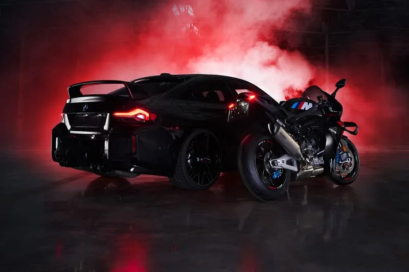 Voiture et moto noires avec fumée rouge en arrière-plan