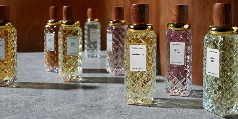 Bouteilles de parfum en verre sur une table grise.