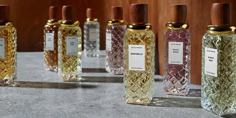 Bouteilles de parfum en verre sur une table grise.
