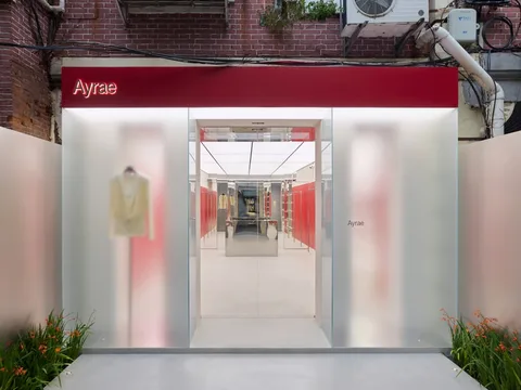 Entrée de boutique moderne avec panneau rouge et plantes.