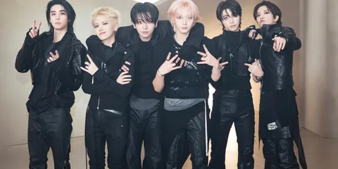 Groupe de jeunes hommes en vêtements noirs posant ensemble.