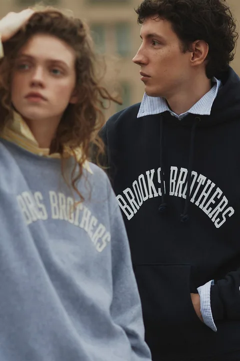 Deux personnes portent des sweats Brooks Brothers.