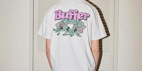 Homme portant un t-shirt blanc avec grenouilles et texte 'Buffer'.