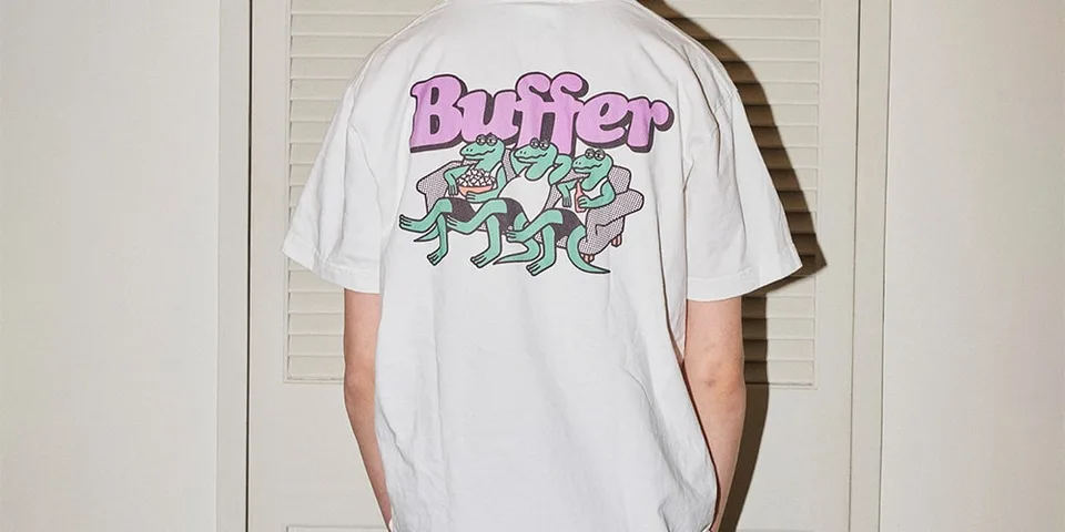 Homme portant un t-shirt blanc avec grenouilles et texte 'Buffer'.
