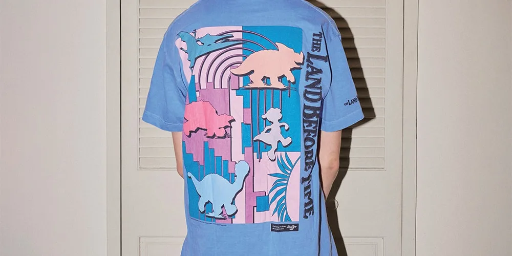 Dos d'un t-shirt bleu avec motifs de dinosaures et texte.