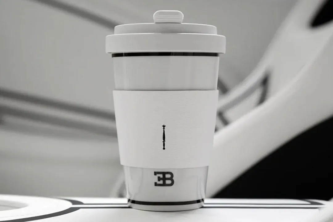 Gobelet de voyage blanc et gris avec un logo discret.