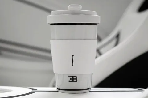Gobelet de voyage blanc et gris avec un logo discret.