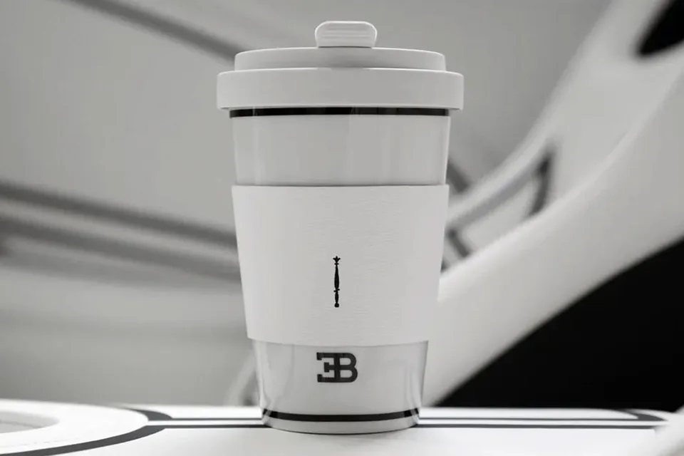 Gobelet de voyage blanc et gris avec un logo discret.