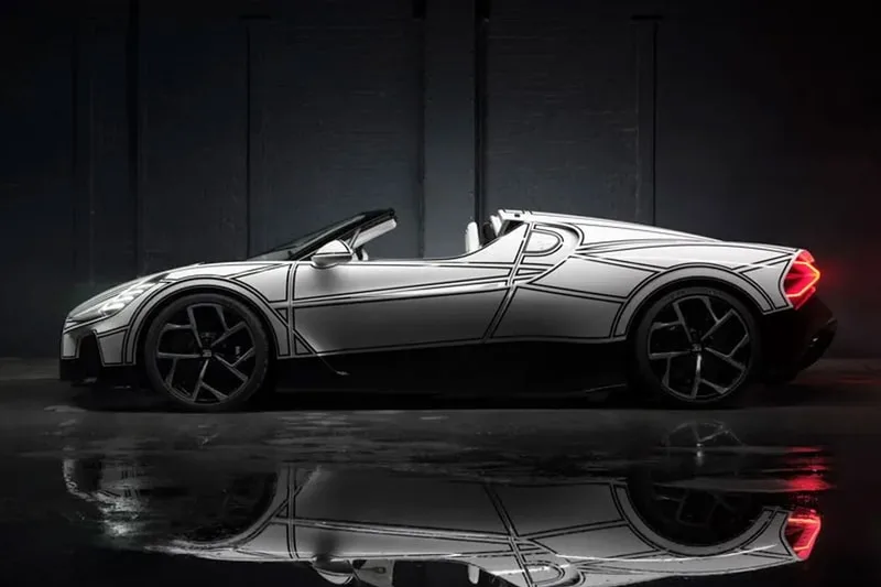 Voiture sportive blanche décapotable sur fond sombre avec son reflet.