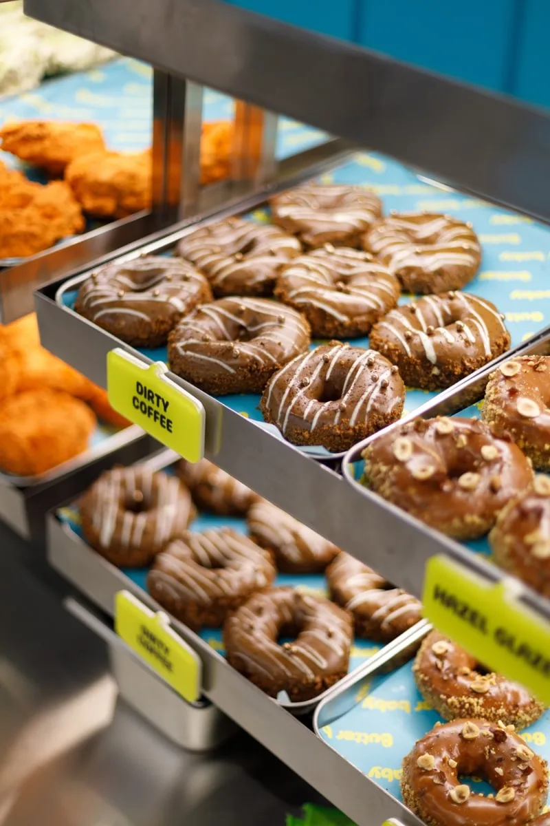 Plateau de beignets avec étiquettes 'Dirty Coffee' et 'Hazel Glazed'.