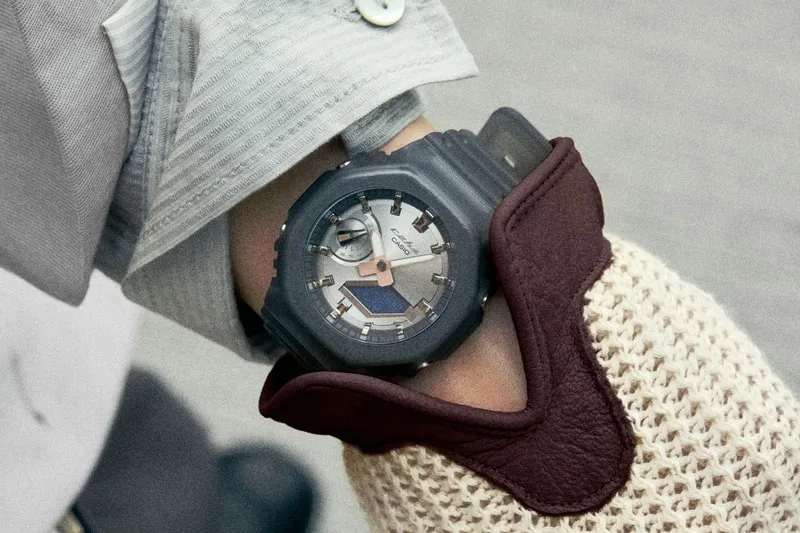 Montre au poignet d'une personne vêtue de vêtements élégants.