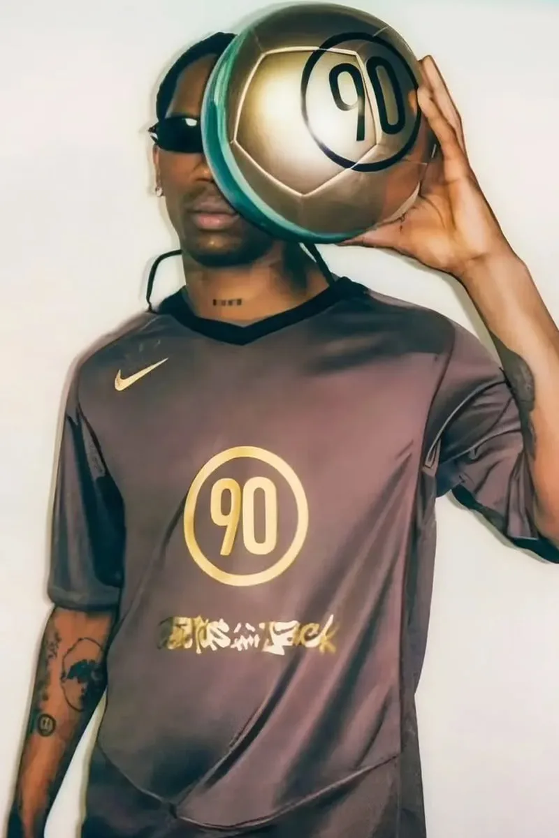 Homme avec t-shirt marron et ballon Nike numéro 90