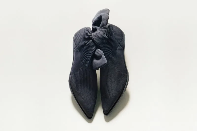 Deux chaussures noires avec des nœuds, vues de dessus sur fond blanc.