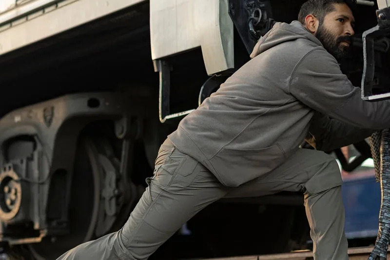 Homme en vêtements décontractés travaille sous un train.