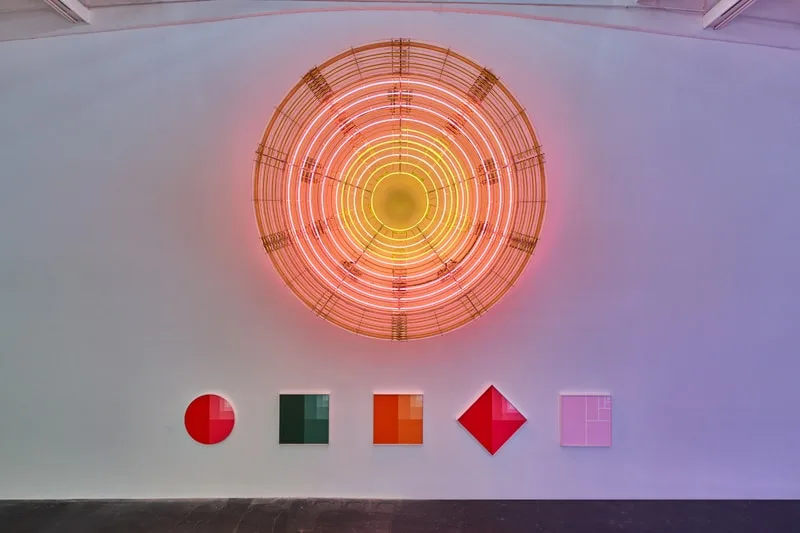 Installation artistique colorée avec formes géométriques et cercle lumineux.