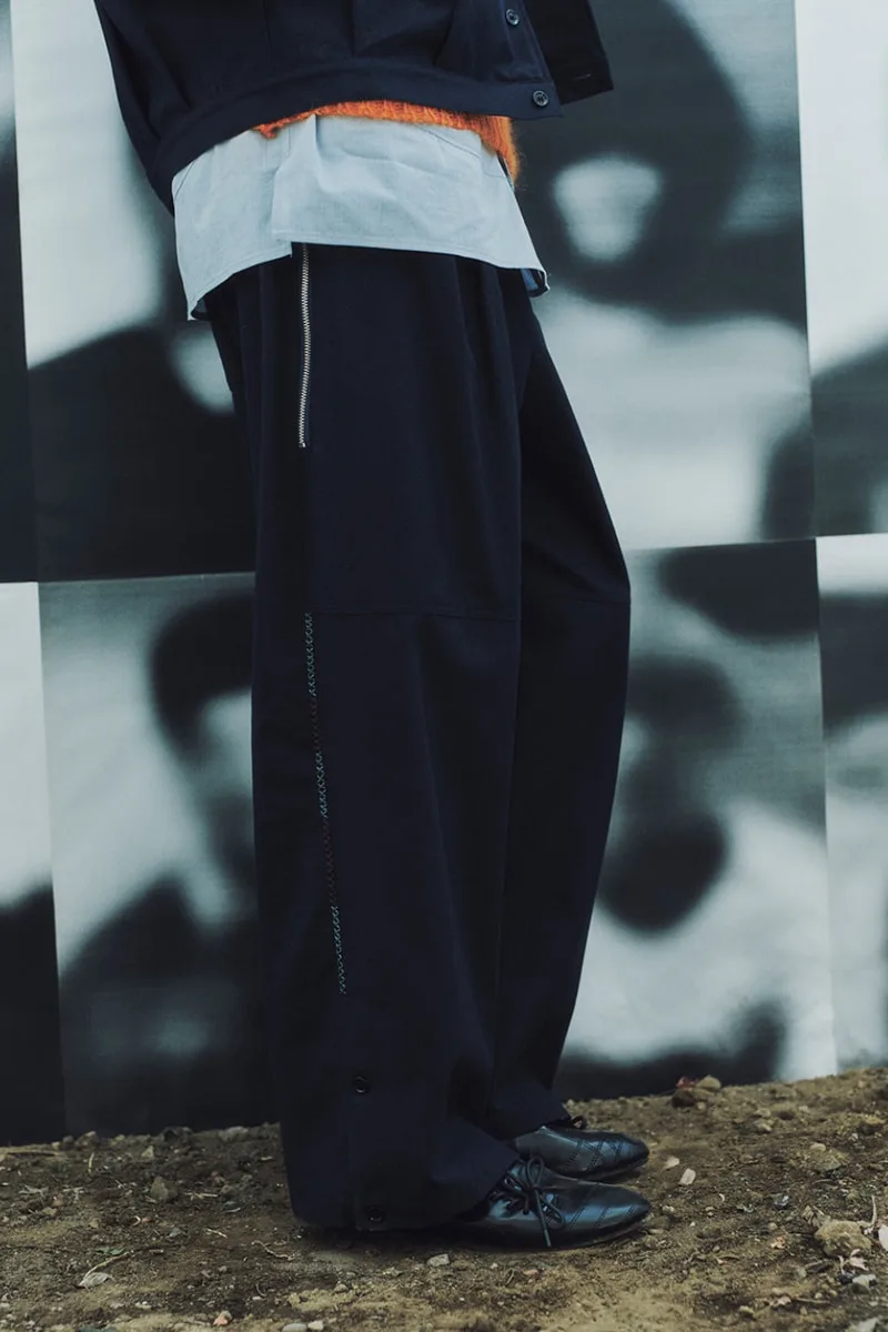 Personne portant un pantalon large noir et chaussures élégantes.