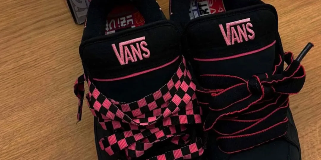 Chaussures Vans avec lacets roses et noirs sur un sol en bois.