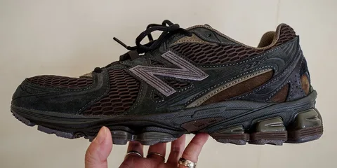 Chaussure New Balance noire avec maillage et semelle épaisse.