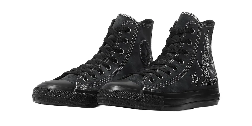 Chaussures noires montantes avec coutures blanches et étoiles.