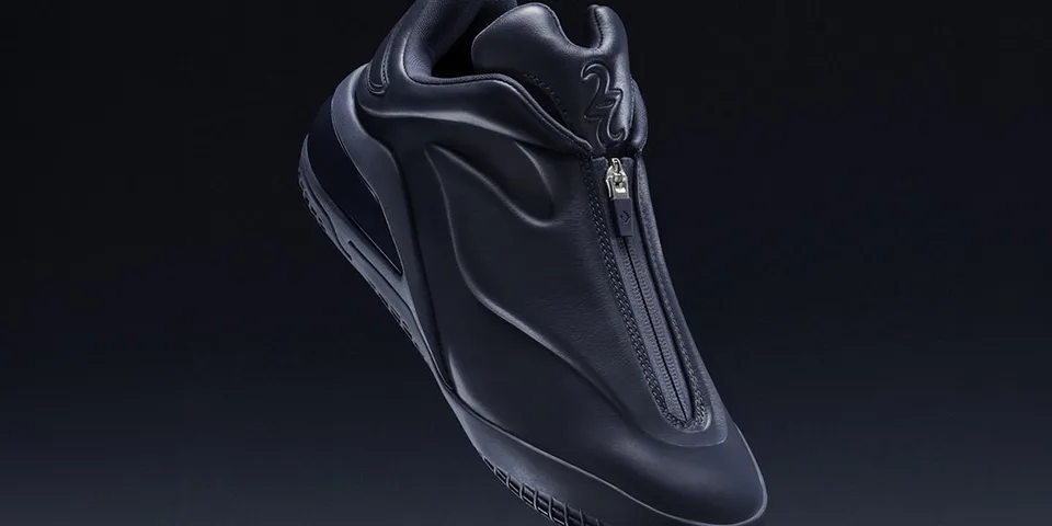 Chaussure noire futuriste avec fermeture éclair centrale.