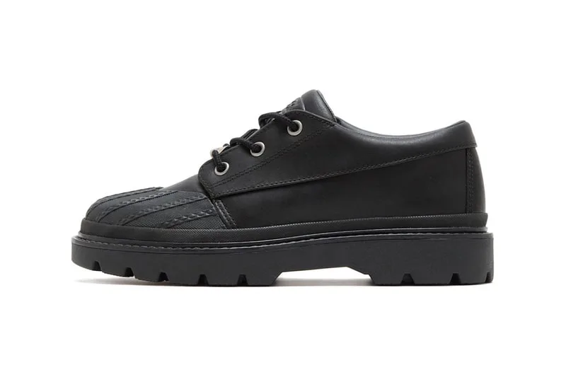 Chaussure basse noire avec semelle épaisse et lacets.