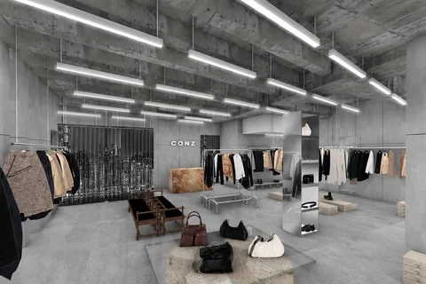 Intérieur de magasin moderne avec vêtements suspendus et sacs à main sur le sol.