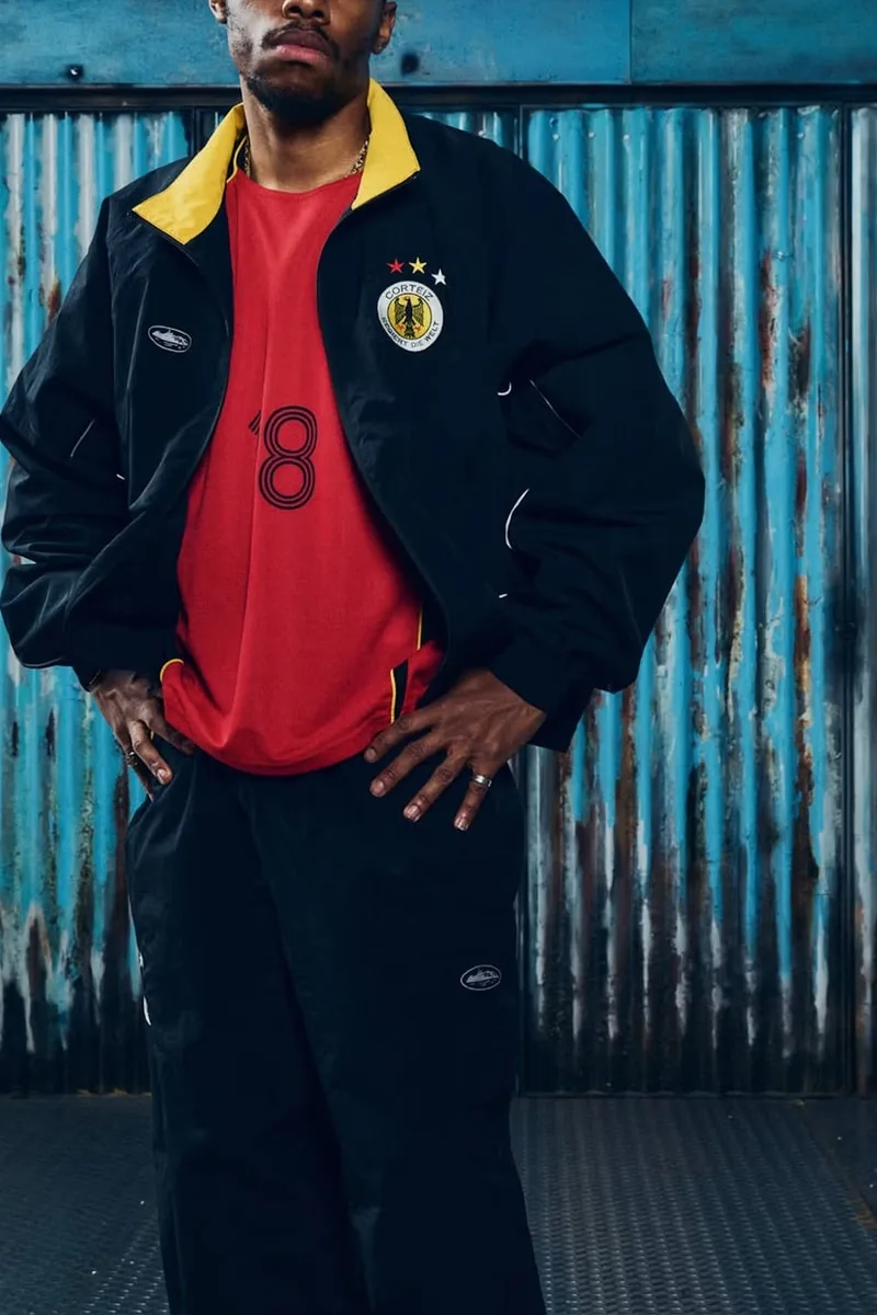 Personne portant un survêtement noir et un maillot rouge avec le chiffre 8.